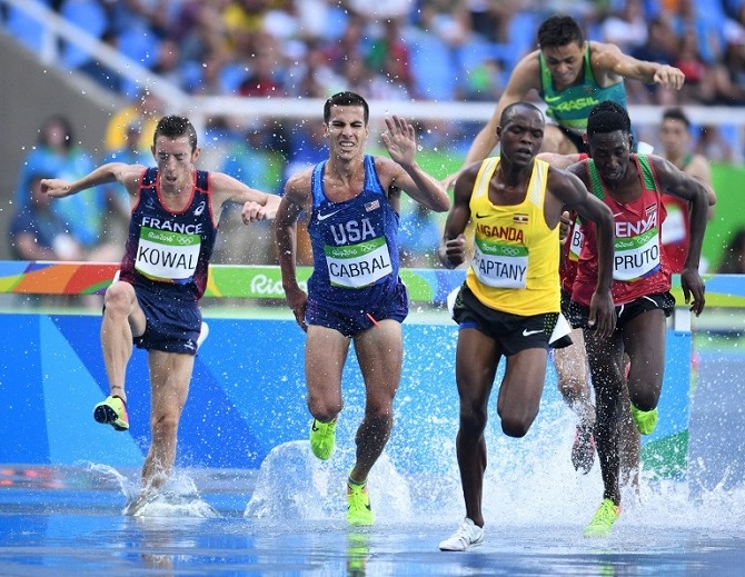 France's Yoann Kowal (L), USA's Donald Cabral (C) and Uganda's Jacob Araptany (2ndR) compete in the Men's 3000m Steeplechase Round 1 during the athletics event at the Rio 2016 Olympic Games at the Olympic Stadium in Rio de Janeiro on August 15, 2016. PHOTO AFP