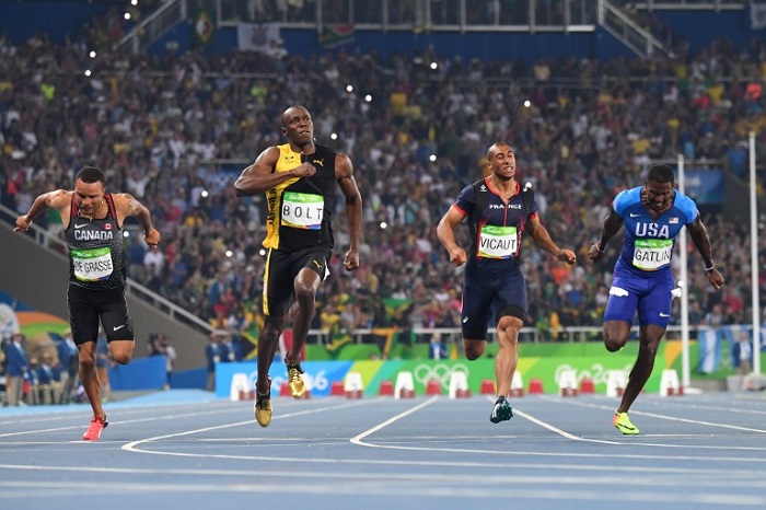 Jamaica's Usain Bolt (2ndL) reacts after he crossed the finish line head of USA's Justin Gatlin (R), Canada's Andre De Grasse (L) and France's Jimmy Vicaut to win the Men's 100m Final during the athletics event at the Rio 2016 Olympic Games at the Olympic Stadium in Rio de Janeiro on August 14, 2016. AFP PHOTO 