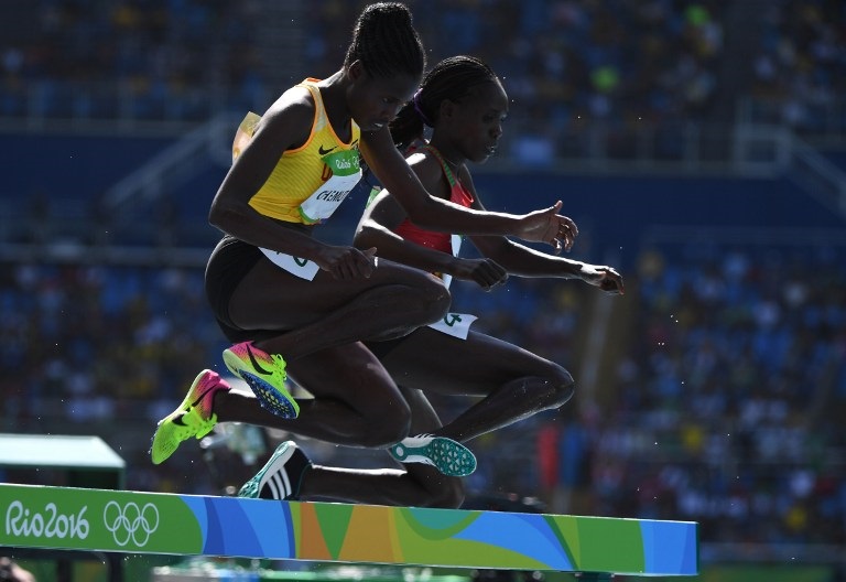 Uganda's Peruth Chemutai (L) competes in the Women's 3000m Steeplechase Round 1 during the athletics event at the Rio 2016 Olympic Games at the Olympic Stadium in Rio de Janeiro on August 13, 2016. / AFP PHOTO / OLIVIER MORIN