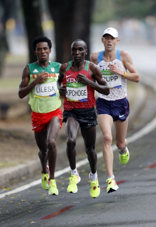 (FromL) Ethiopia's Feyisa Lilesa, Kenya's Eliud Kipchoge and USA's Galen Rupp run during the Men's Marathon athletics event at the Rio 2016 Olympic Games in Rio de Janeiro on August 21, 2016. / AFP PHOTO / Adrian DENNIS