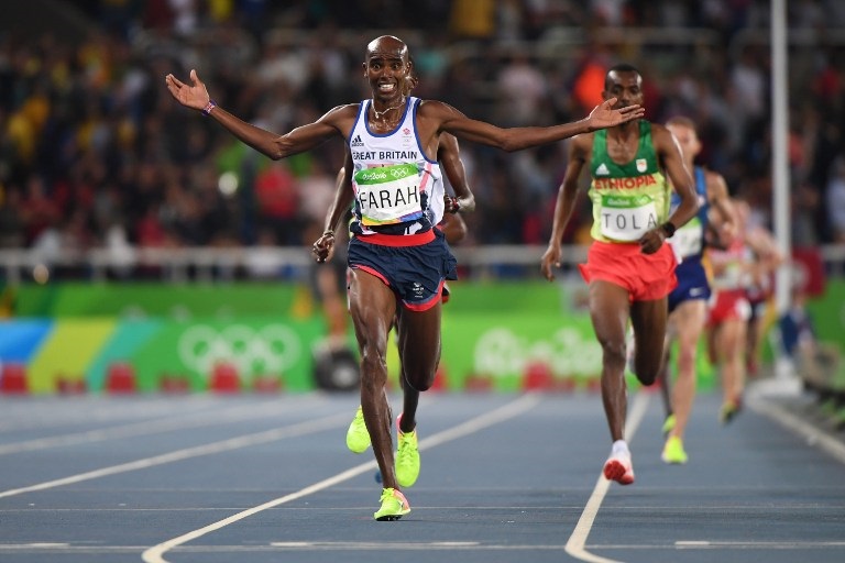 Britain's Mo Farah celebrates as he crosses the finish line to win the Men's 10,000m during the athletics event at the Rio 2016 Olympic Games at the Olympic Stadium in Rio de Janeiro on August 13, 2016. / AFP PHOTO / OLIVIER MORIN