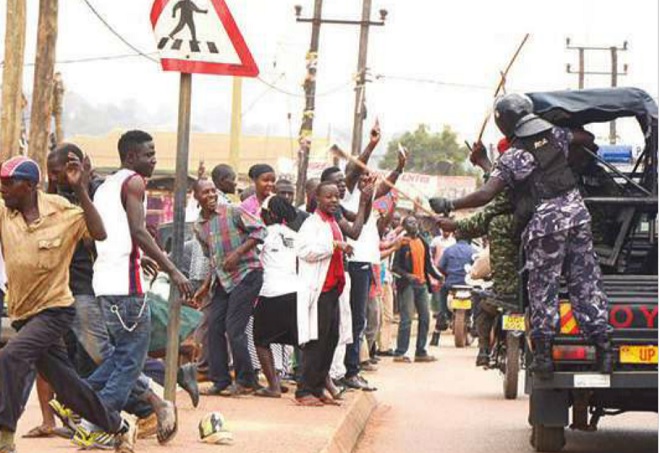 Police cane by-standers as they waved at FDC's Kizza Besigye after he had been freed from prison. File photo